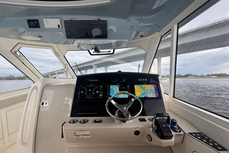  Yacht Photos Pics 2018 Boston Whaler 380 Realm helm with navigation screens, steering wheel, and water view.