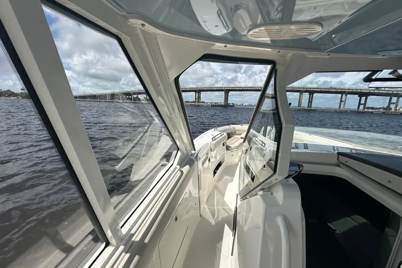  Yacht Photos Pics 2023 Boston Whaler 380 Realm interior view with open windows, overlooking a bridge and water.