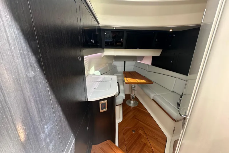  Yacht Photos Pics 2023 Boston Whaler 380 Realm interior with sleek seating and wooden table.