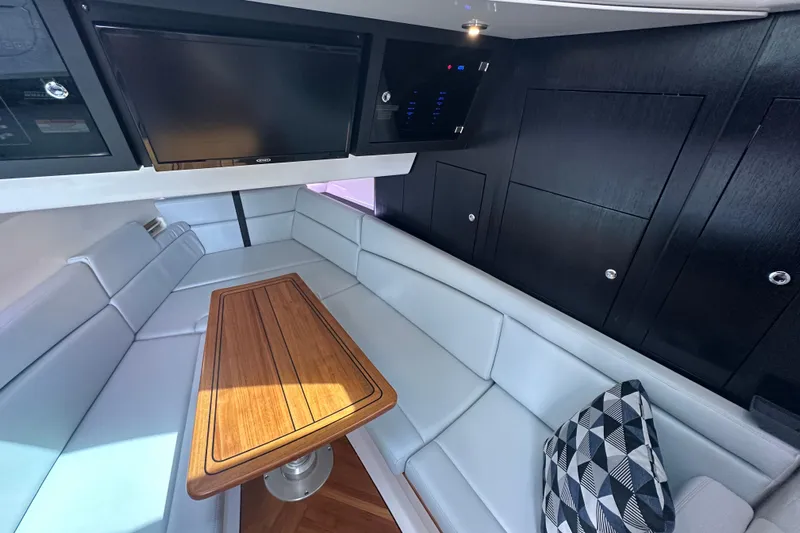  Yacht Photos Pics Luxurious interior of 2023 Boston Whaler 380 Realm with sleek seating and wooden table.