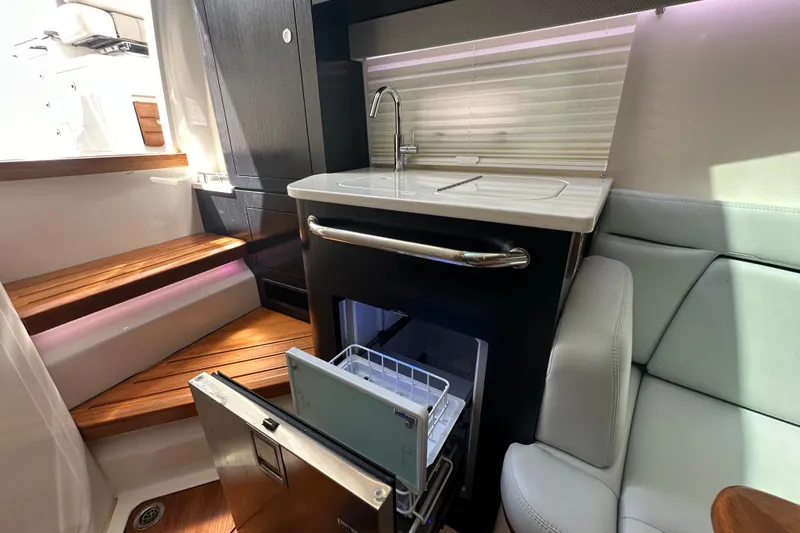  Yacht Photos Pics 2023 Boston Whaler 380 Realm interior with kitchenette, sink, and seating area.