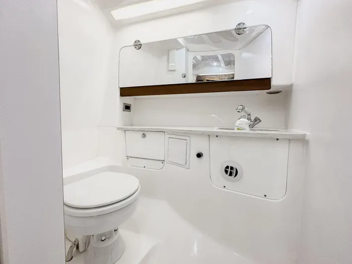 Yacht Photos Pics 2017 Everglades 360 LXC boat bathroom with white fixtures and storage.