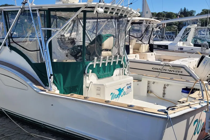 Wave Dancer Yacht Photos Pics 2002 SeaTek 36 Express boat docked, featuring green canopy and sleek design.