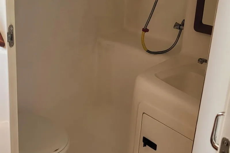 Wave Dancer Yacht Photos Pics 2002 SeaTek 36 Express boat bathroom with toilet, sink, and showerhead.