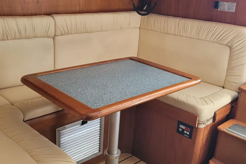 Wave Dancer Yacht Photos Pics Cozy interior of 2002 SeaTek 36 Express with cushioned seating and wooden table.