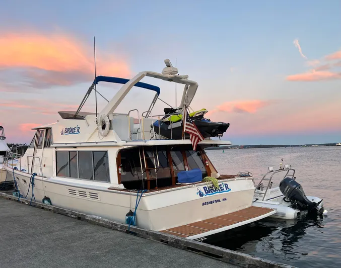  Yacht Photos Pics 1988 Bayliner 4588 yacht docked at sunset with American flag and jet ski.