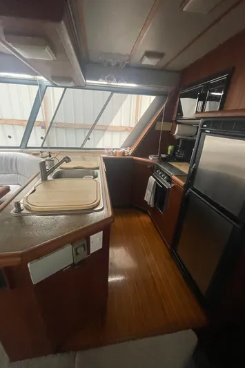  Yacht Photos Pics 1988 Bayliner 4588 yacht kitchen with wood flooring, modern appliances, and large windows.