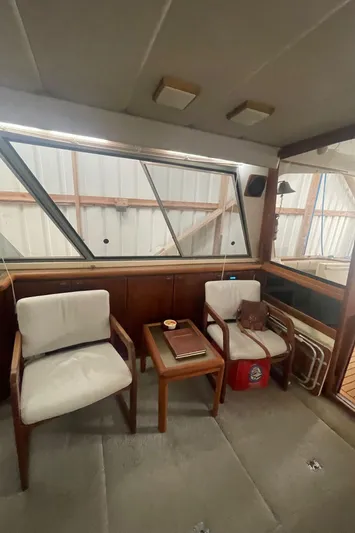  Yacht Photos Pics Interior of 1988 Bayliner 4588 yacht with chairs and table, showcasing classic design.