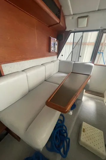  Yacht Photos Pics Interior of 1988 Bayliner 4588 yacht with white seating and wooden table.