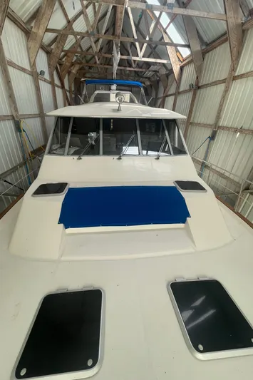  Yacht Photos Pics 1988 Bayliner 4588 yacht in a wooden boathouse, showcasing its sleek design and structure.