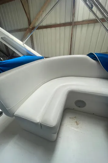  Yacht Photos Pics 1988 Bayliner 4588 boat interior with white cushioned seating and blue cover.