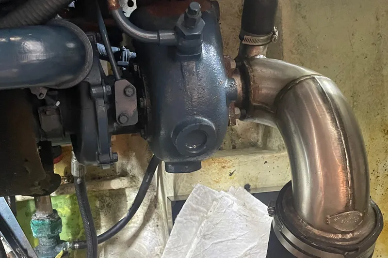  Yacht Photos Pics Engine component of a 1988 Bayliner 4588 boat, featuring metal pipes and connections.