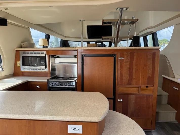Captain & The Kids Yacht Photos Pics Interior of 1998 Carver 530 Voyager yacht with kitchen and wooden cabinetry.