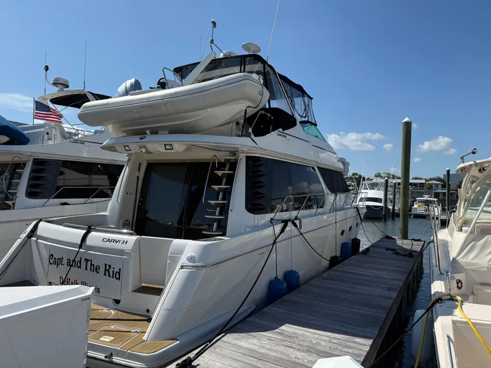 Captain & The Kids Yacht Photos Pics 1998 Carver 530 Voyager yacht docked at marina under clear blue sky.