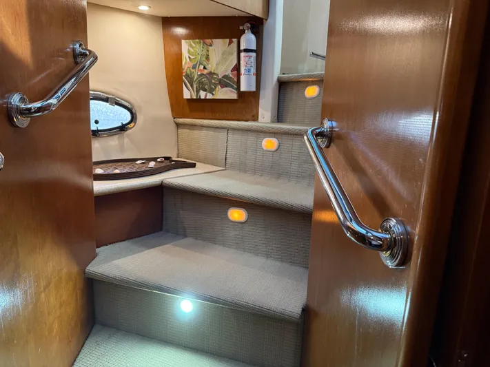 Captain & The Kids Yacht Photos Pics Staircase inside 1998 Carver 530 VOYAGER yacht with elegant lighting and wooden handrails.