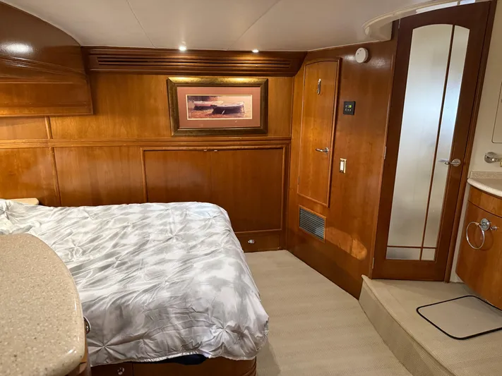 Captain & The Kids Yacht Photos Pics Luxurious 1998 Carver 530 VOYAGER yacht bedroom with wood paneling and cozy bedding.