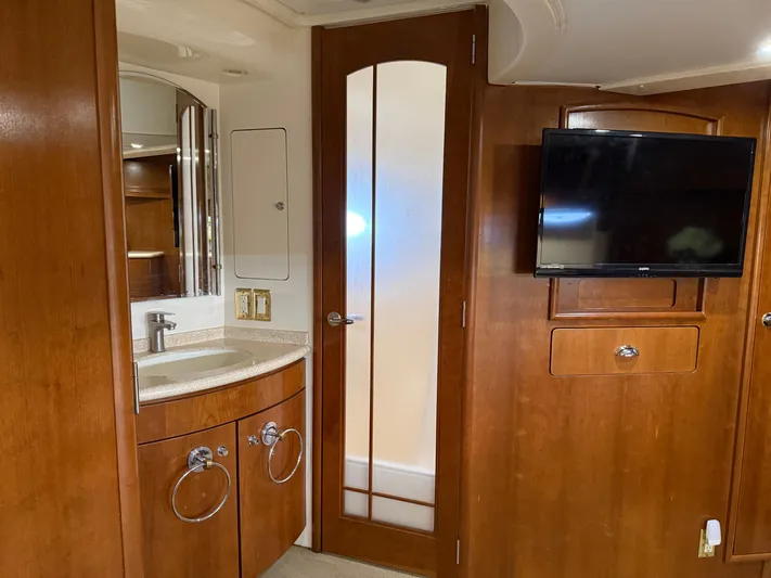 Captain & The Kids Yacht Photos Pics 1998 Carver 530 VOYAGER interior with wooden cabinetry, sink, and mounted TV.