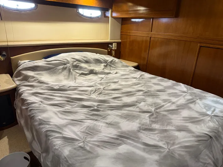 Captain & The Kids Yacht Photos Pics Cozy bedroom interior of 1998 Carver 530 Voyager yacht with wooden paneling.