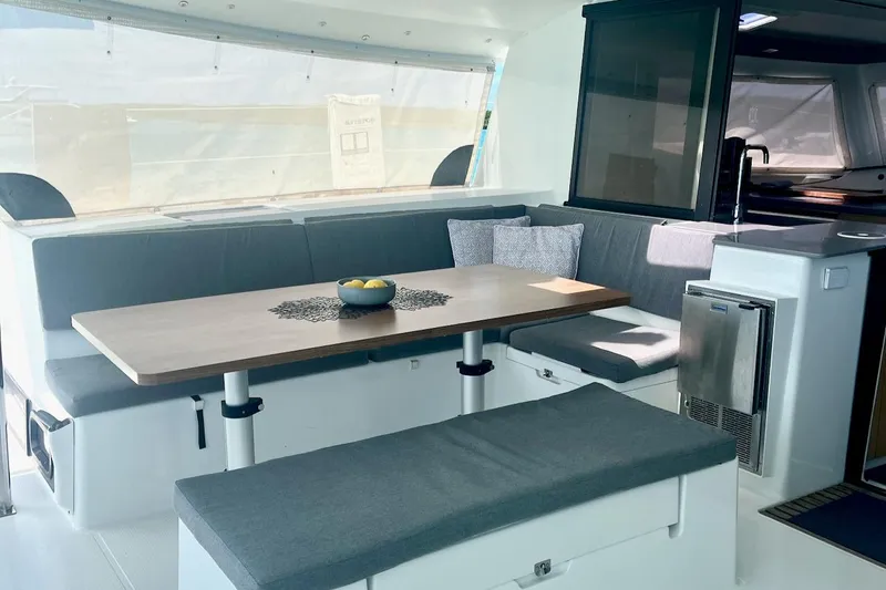 Still Knot A Clue Yacht Photos Pics Luxurious interior of 2015 Fountaine Pajot Helia Maestro catamaran with modern seating and dining area.