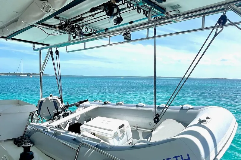 Still Knot A Clue Yacht Photos Pics Fountaine Pajot Helia Maestro 2015 catamaran with dinghy, overlooking clear turquoise waters.