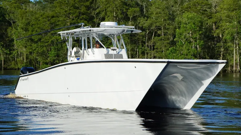  Yacht Photos Pics 2023 Freeman 34VH boat cruising on a calm river with lush green forest backdrop.