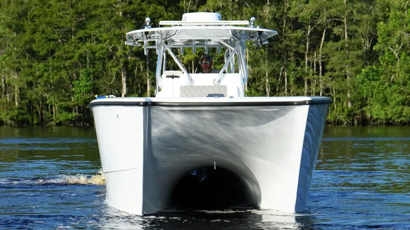  Yacht Photos Pics 2023 Freeman 34VH boat cruising on a calm river with lush green forest backdrop.