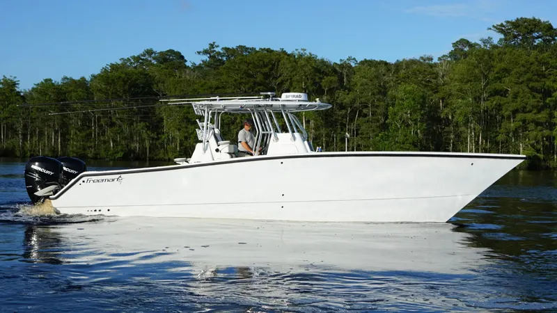  Yacht Photos Pics 2023 Freeman 34VH boat cruising on a calm river with forested background.