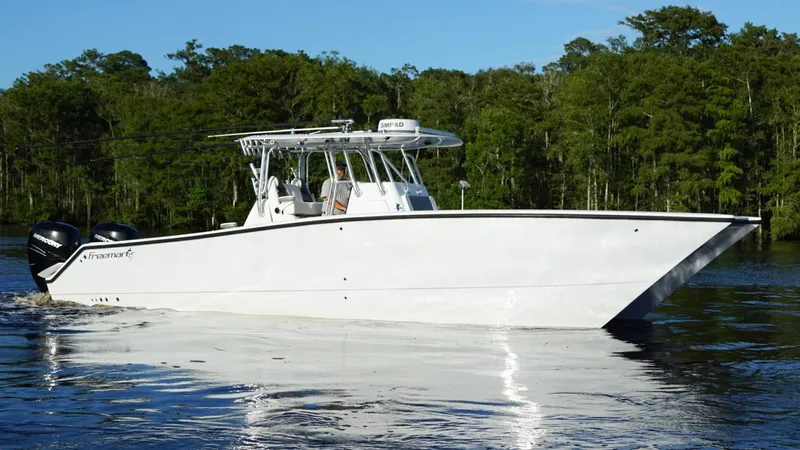  Yacht Photos Pics 2023 Freeman 34VH boat cruising on a calm river with lush green trees.