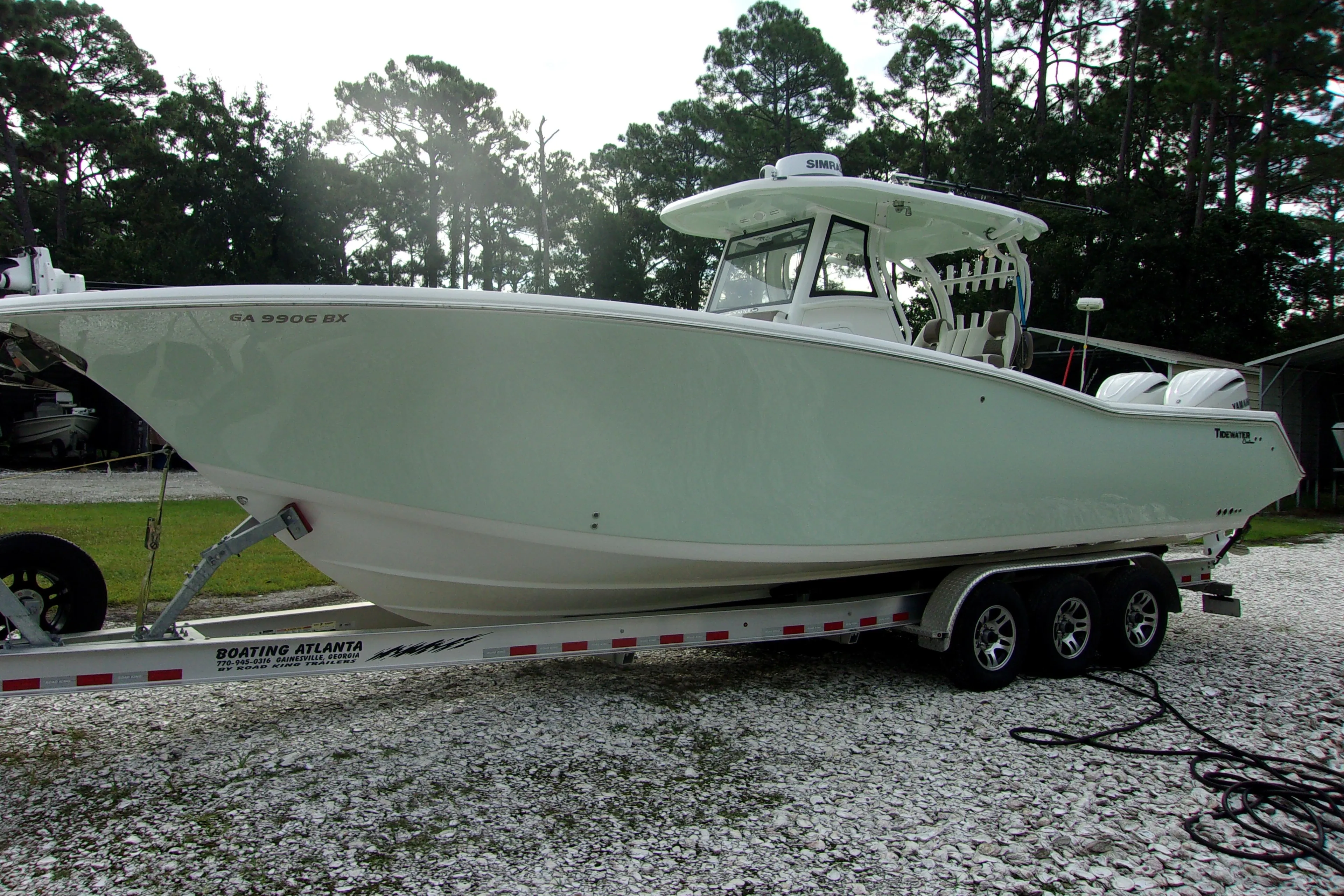 2025 Tidewater 320 CC Adventure boat on trailer, parked outdoors.