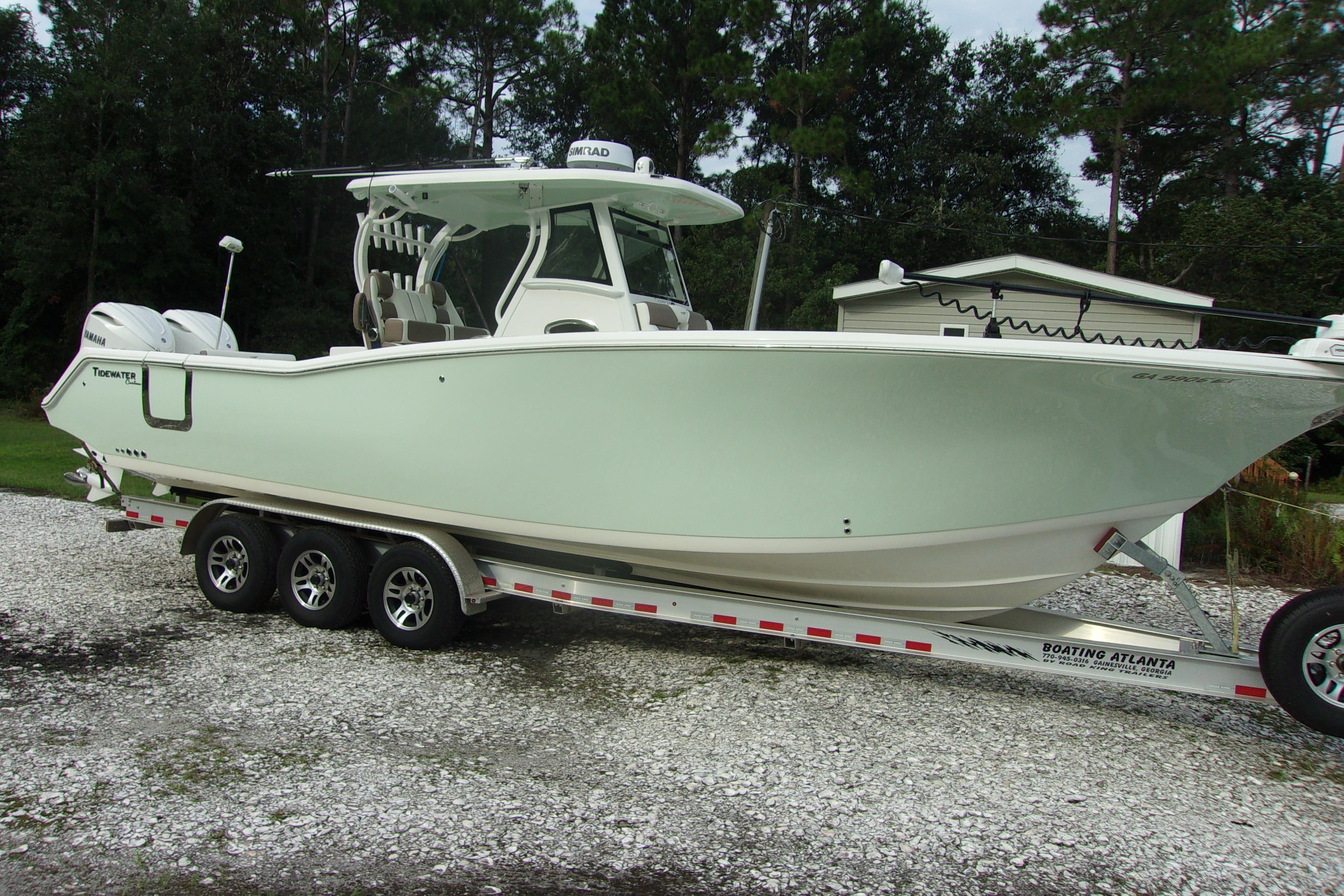 2025 Tidewater 320 CC Adventure boat on trailer, parked outdoors.