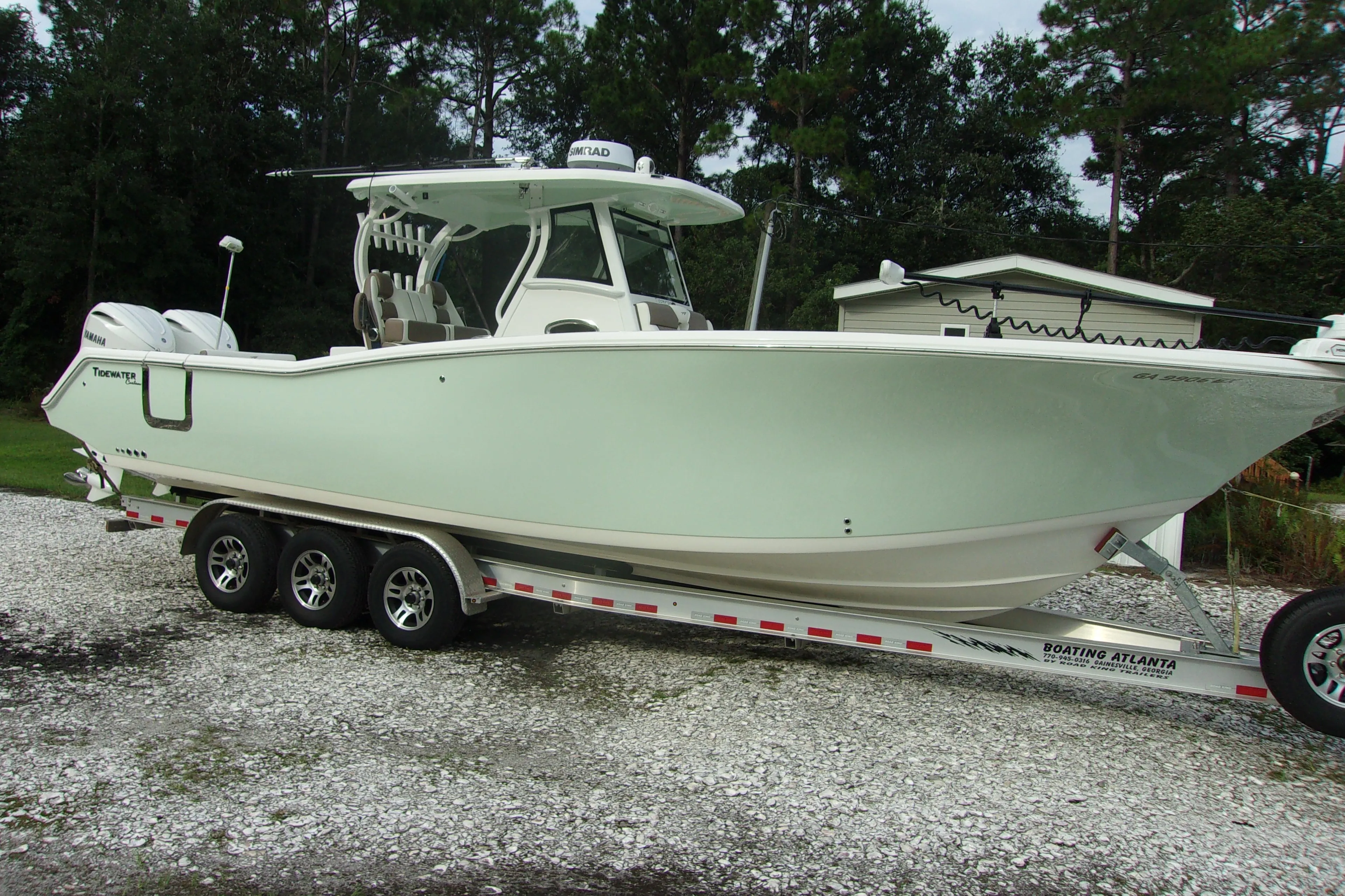 2025 Tidewater 320 CC Adventure boat on trailer, parked outdoors.
