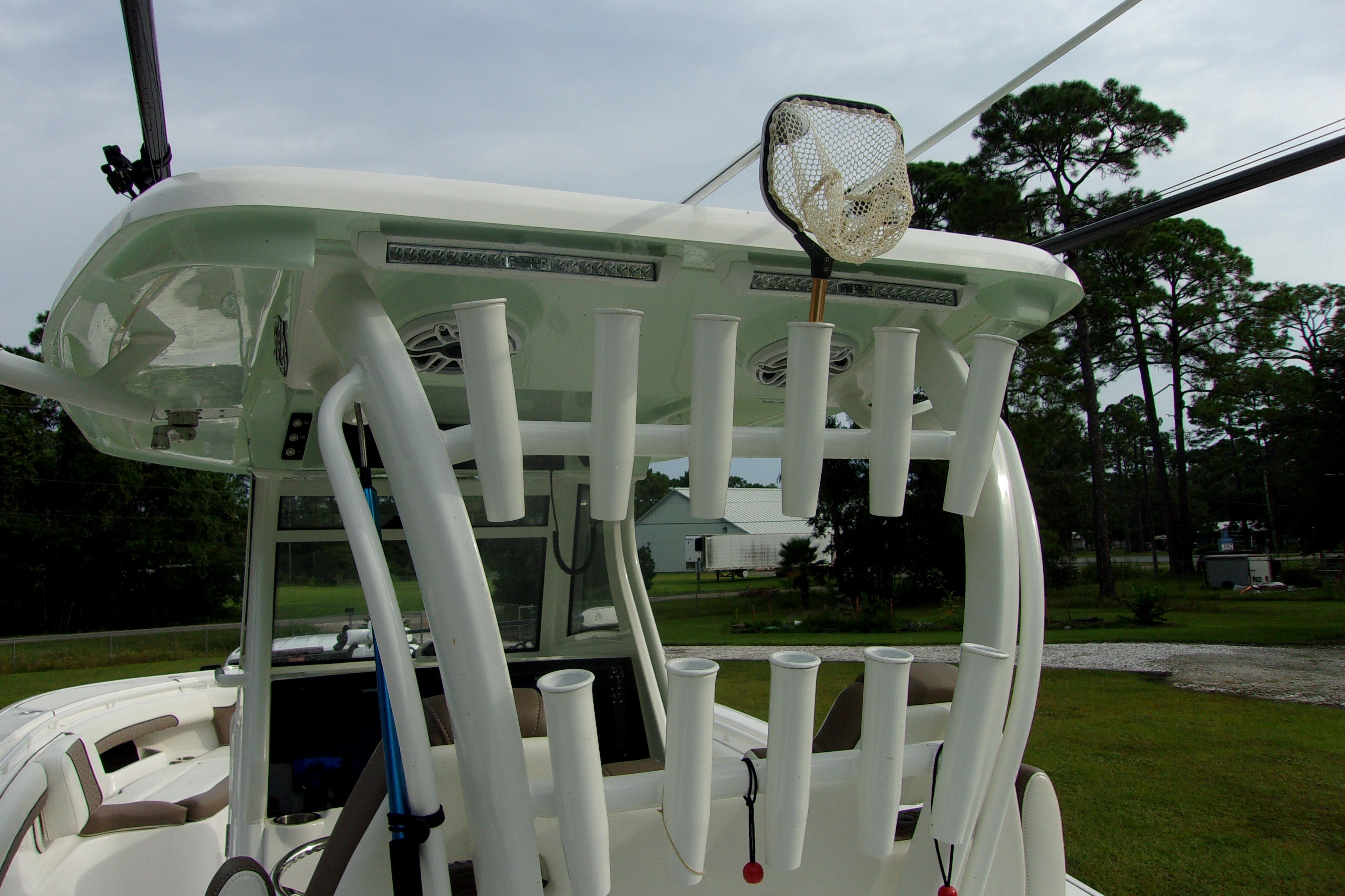 2025 Tidewater 320 CC Adventure boat with rod holders and fishing net, parked outdoors.
