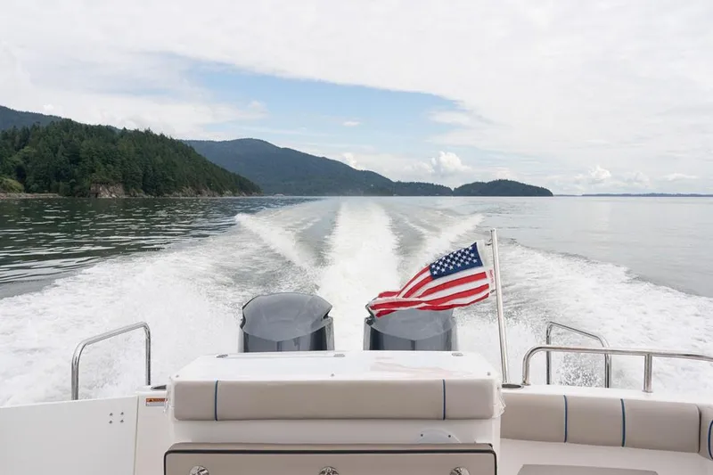  Yacht Photos Pics Manufacturer Provided Image: 2022 Cutwater C-32 CB boat cruising on a lake with an American flag.