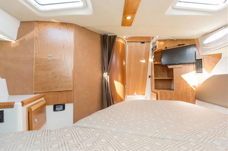  Yacht Photos Pics Manufacturer Provided Image: 2022 Cutwater C-32 CB cabin interior with wood finishes and a mounted TV.