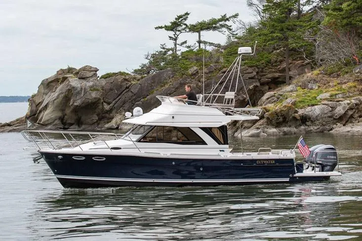  Yacht Photos Pics Manufacturer Provided Image: 2022 Cutwater C-32 CB boat cruising near rocky shoreline with trees.
