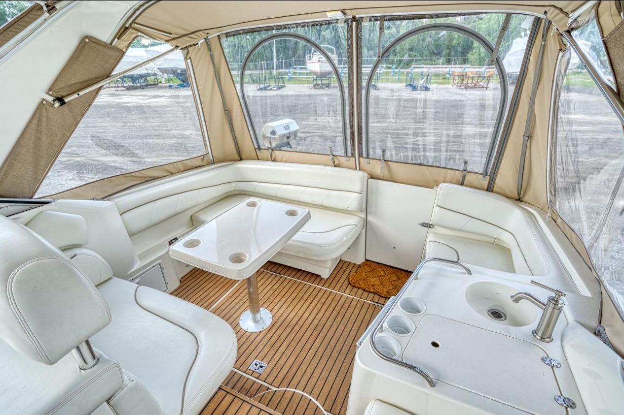 2002 Larson Cabrio 330 boat interior with white seating, table, and sink.