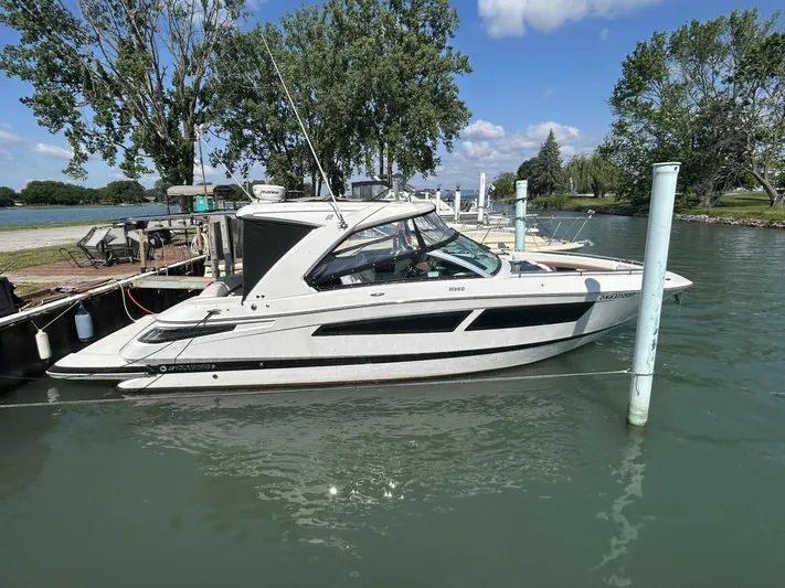  Yacht Photos Pics 2017 Four Winns H350 boat docked on a calm lake under a clear blue sky.