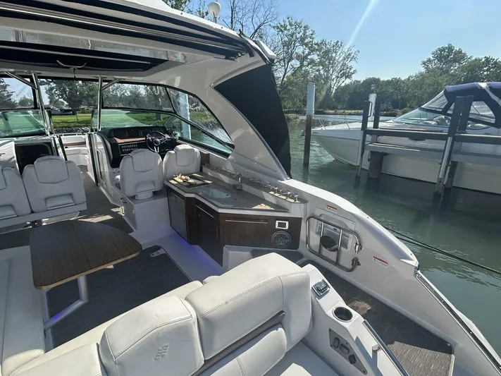  Yacht Photos Pics 2017 Four Winns H350 boat interior with seating and kitchenette, docked by the water.