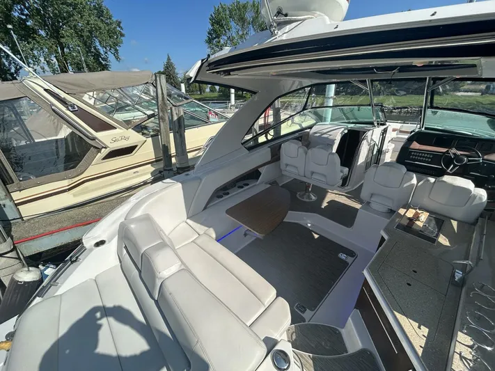  Yacht Photos Pics 2017 Four Winns H350 boat interior with seating and helm, docked alongside other boats.