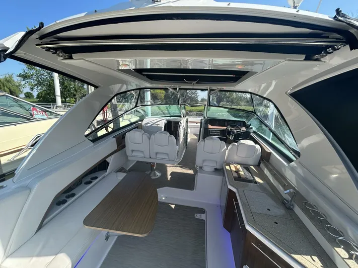  Yacht Photos Pics Interior of 2017 Four Winns H350 boat with seating and table under open roof.