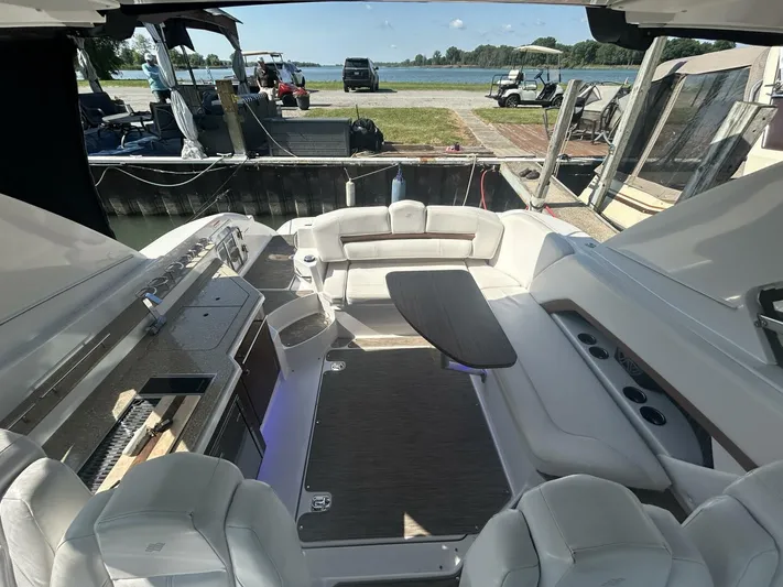 Yacht Photos Pics Luxurious 2017 Four Winns H350 boat interior with seating and table, docked by the water.
