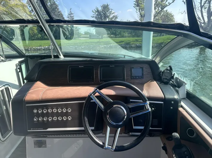  Yacht Photos Pics Cockpit view of 2017 Four Winns H350 boat with steering wheel and control panel.