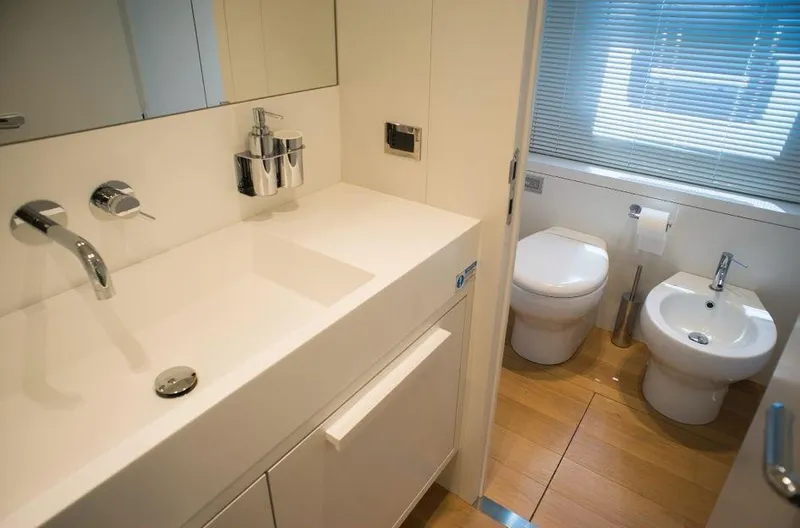  Yacht Photos Pics Luxury bathroom in 2022 Cranchi Settantotto 78 yacht, featuring modern fixtures and wooden flooring.