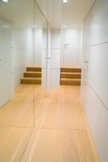  Yacht Photos Pics Interior of 2022 Cranchi Settantotto 78 yacht with sleek wooden flooring and mirrored walls.