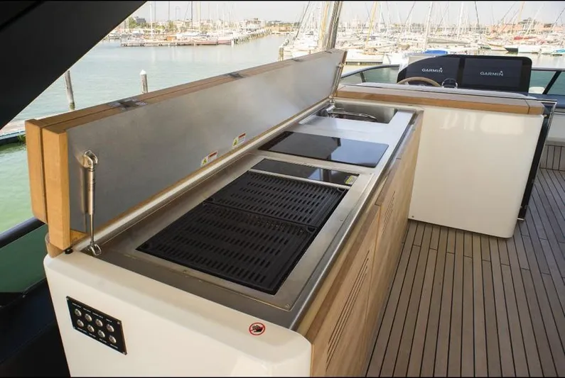  Yacht Photos Pics Outdoor kitchen on 2022 Cranchi Settantotto 78 yacht with grill and sink, docked at marina.