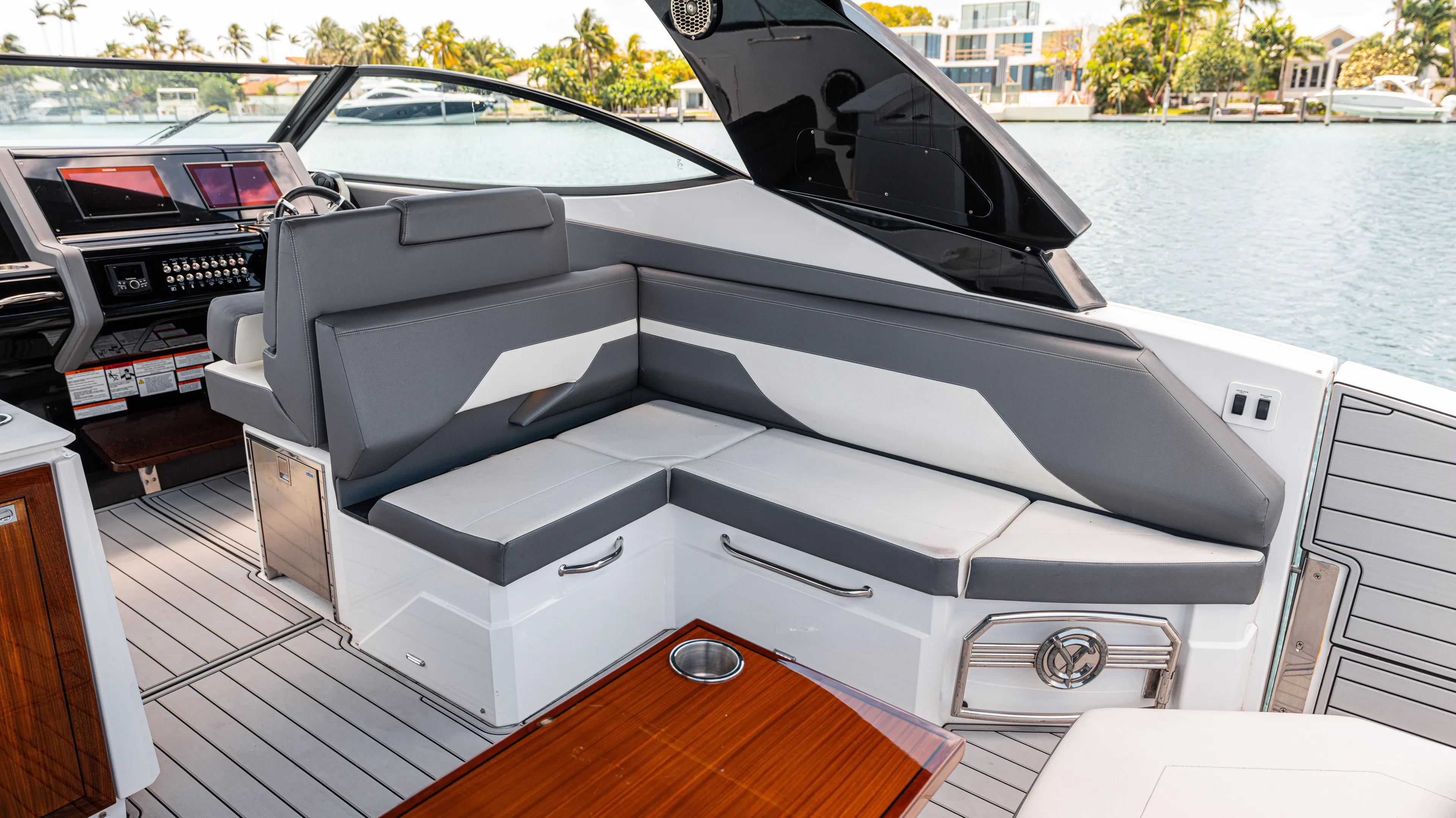  Yacht Photos Pics 2020 Cruisers Yachts 38 GLS OB interior with gray seating and wooden table by the water.