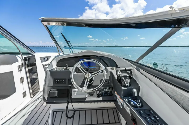  Yacht Photos Pics 2022 Regal 33 OBX boat cockpit with steering wheel, controls, and ocean view.