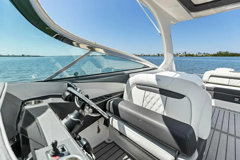  Yacht Photos Pics 2022 Regal 33 OBX boat interior with luxurious seating and steering, overlooking serene waters.