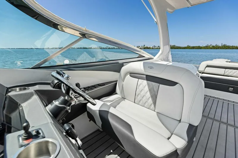  Yacht Photos Pics 2022 Regal 33 OBX boat interior with luxurious seating and steering, overlooking serene waters.