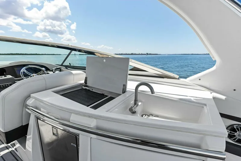  Yacht Photos Pics 2022 Regal 33 OBX yacht interior with sink and grill, overlooking serene ocean view.